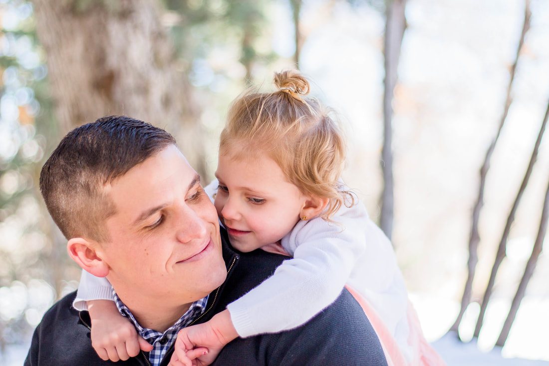 Father holding his daughter close in winter light